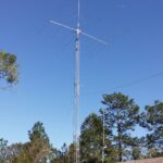 A tall metal tower with wires hanging from it's sides.