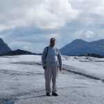 A man standing on top of a snow covered slope.