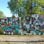 A wall of signs is covered with many different types.